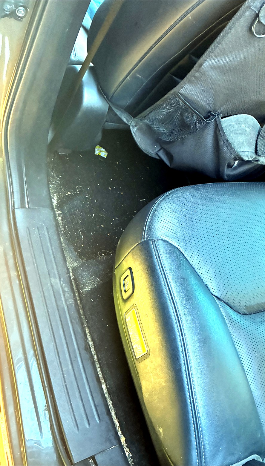 Car footwell covered in dirt and grime before detailing