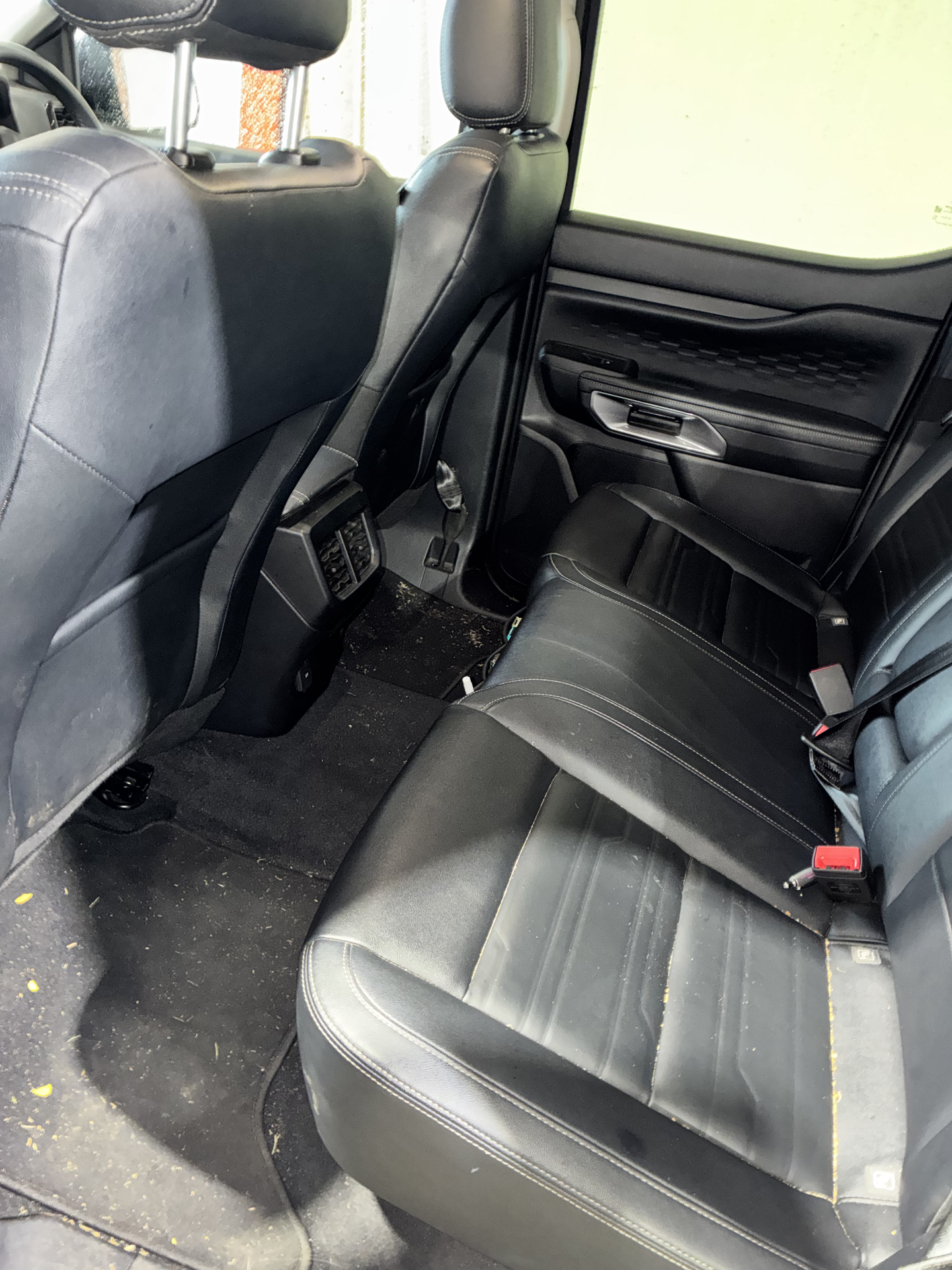 Car interior before detailing with dirt and debris on the seats and floor
